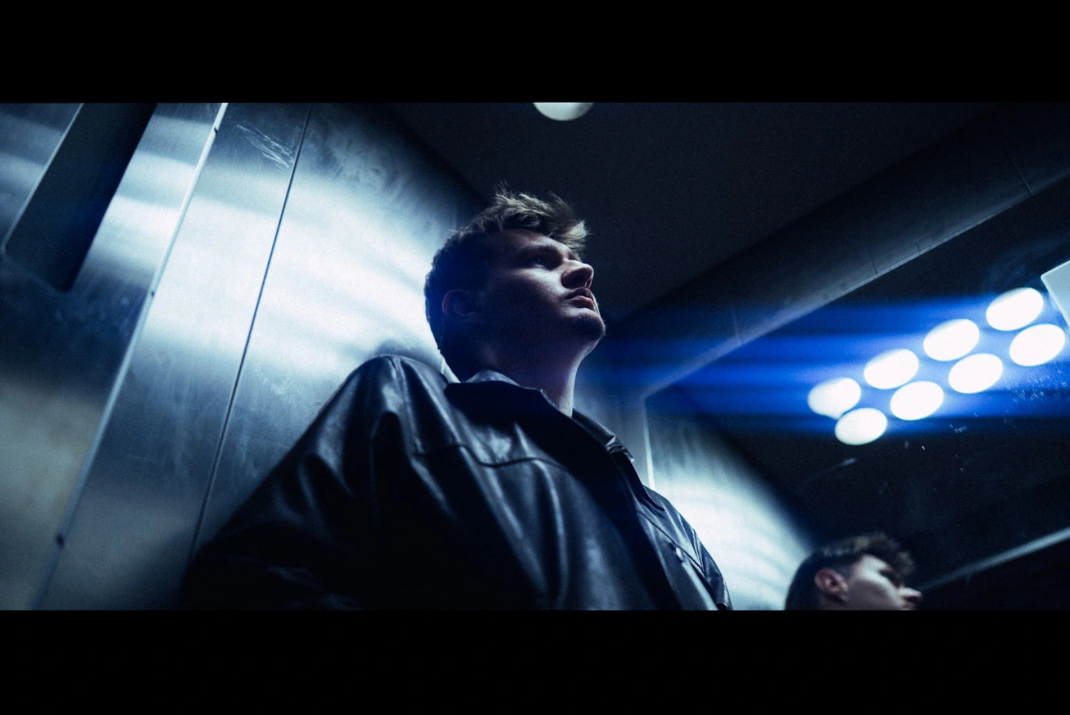 Man in a lift under cold blue light