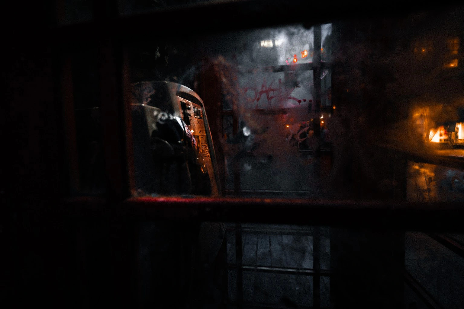 Moody reflections with orange light behind glass