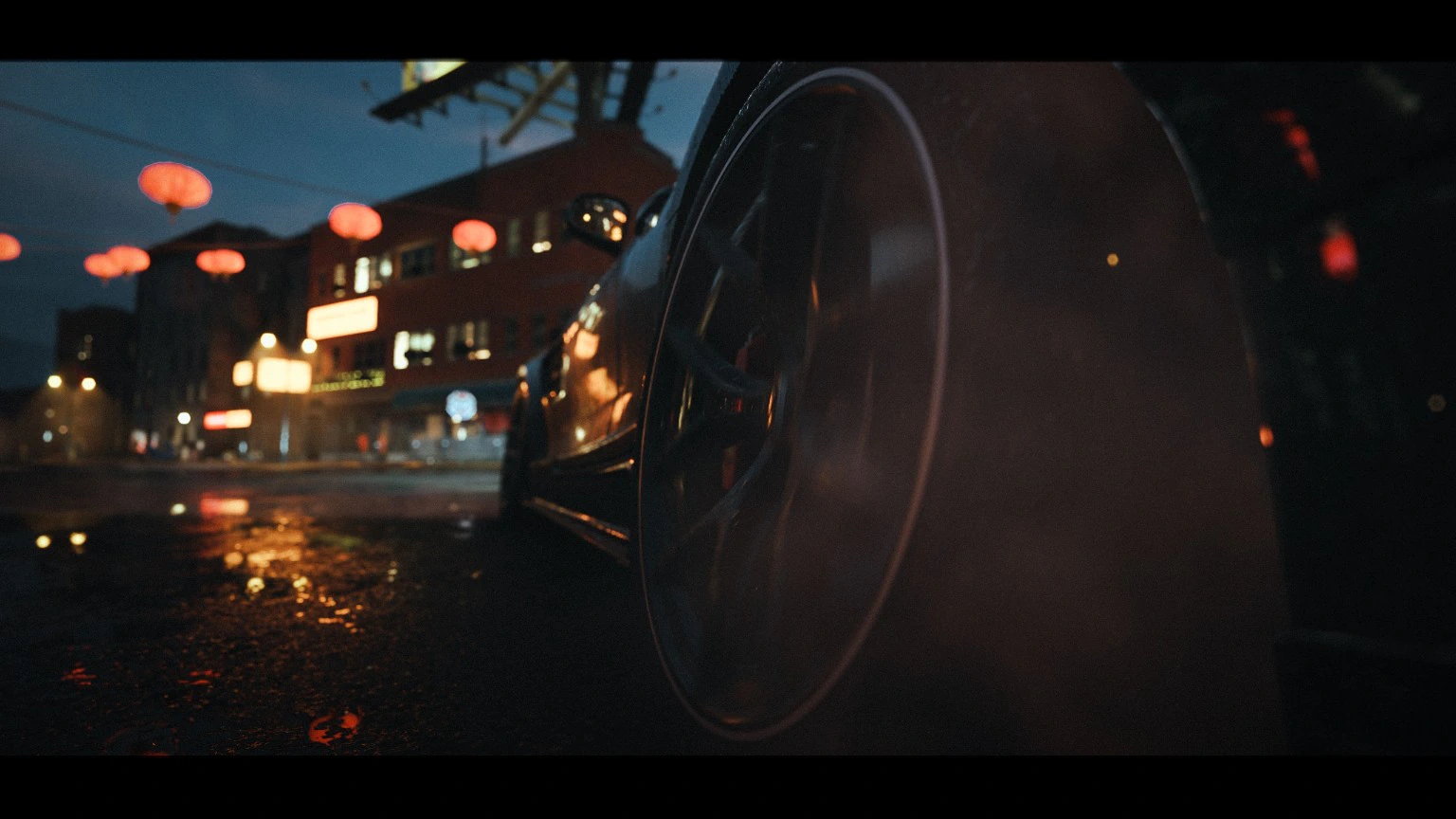 Close view of a sports-car wheel beneath lanterns at night
