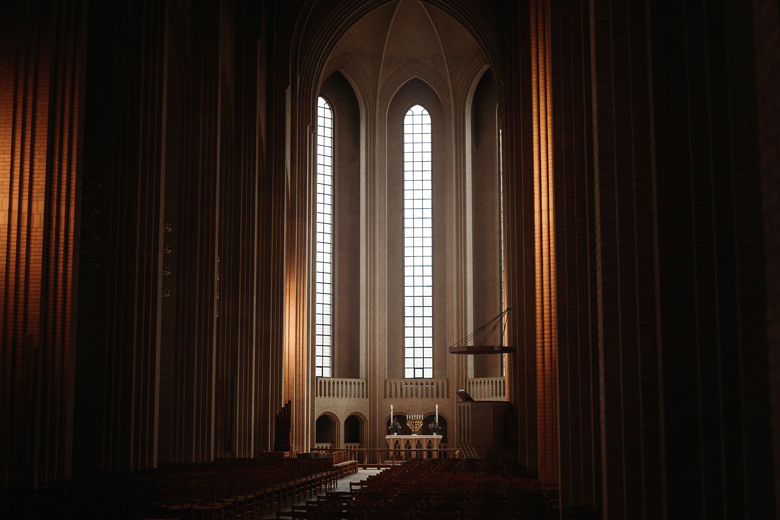 Tall windows and the altar framed by the warm brick interior of Grundtvig's Church