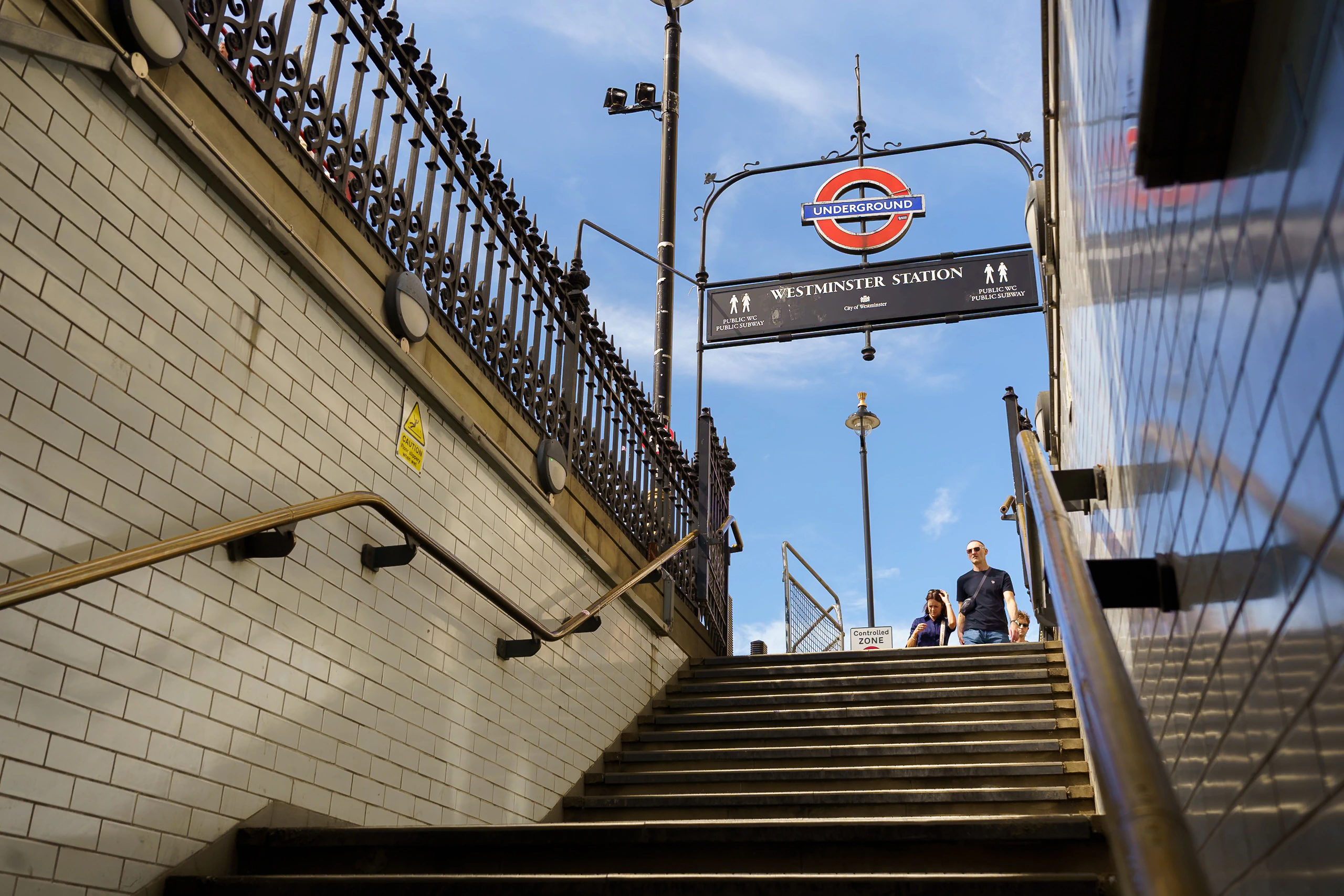 People emerging from Westminster Underground station into bright daylight