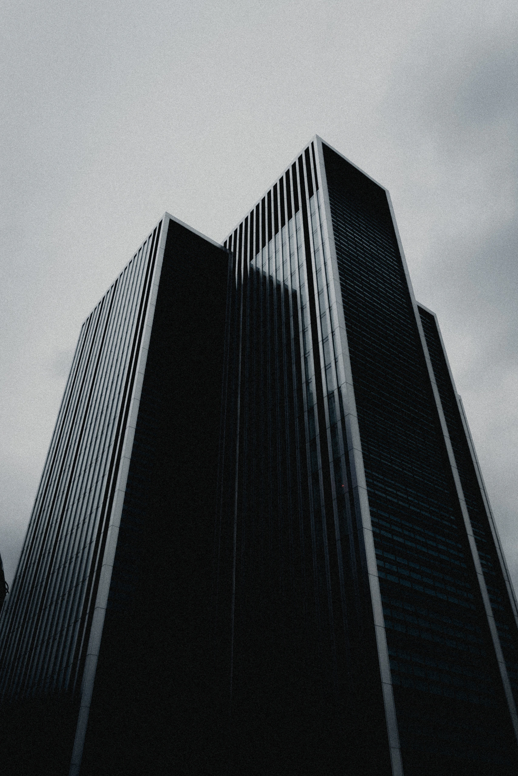 A tall dark office building photographed from street level