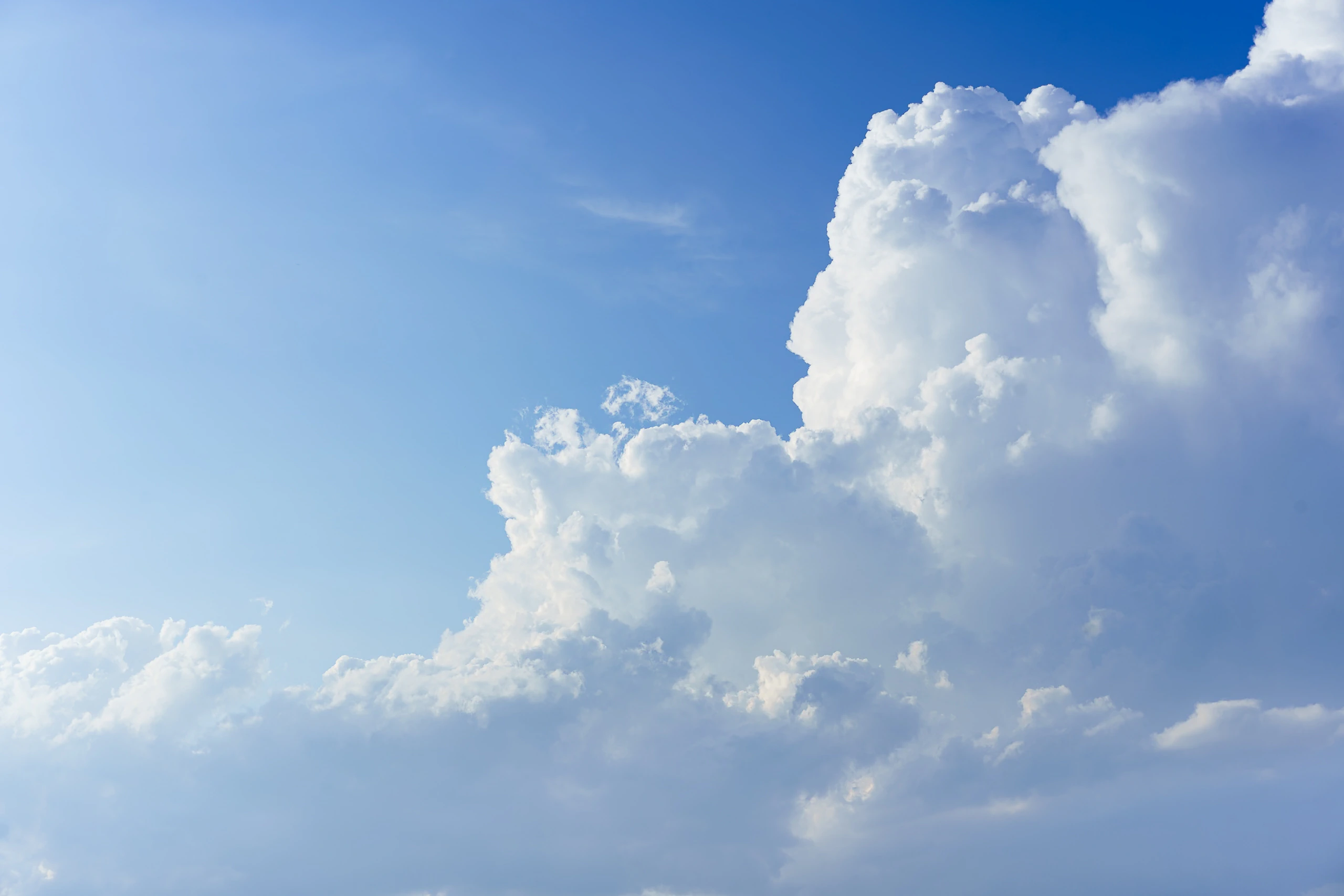 Bright cumulus clouds against a blue sky