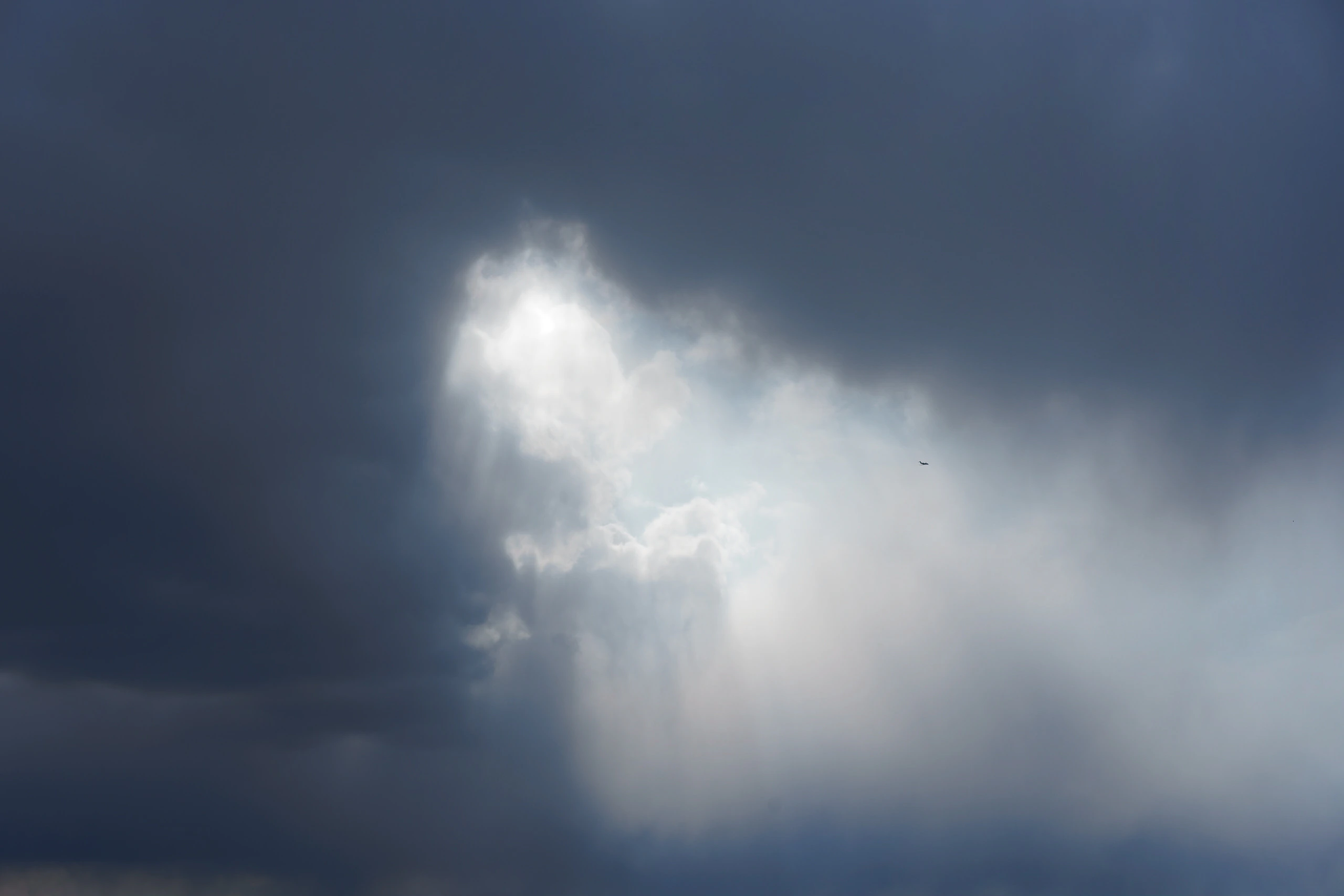 A bright opening cut through dark storm clouds