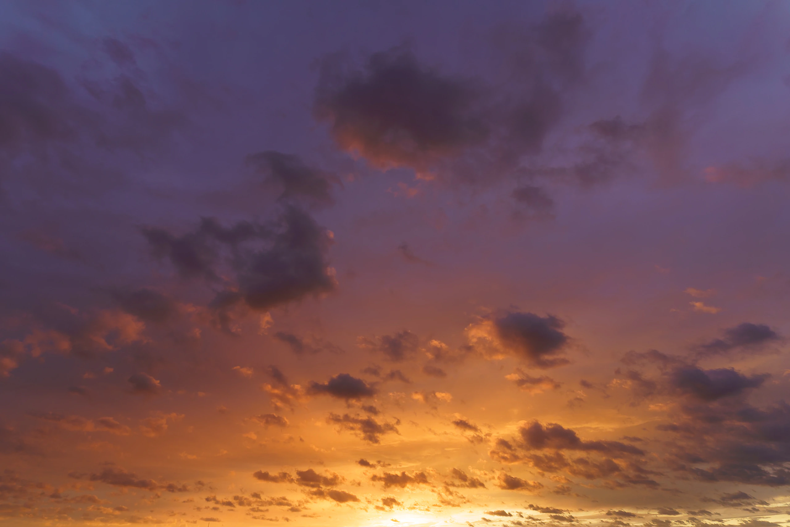 Purple evening clouds above a glowing horizon