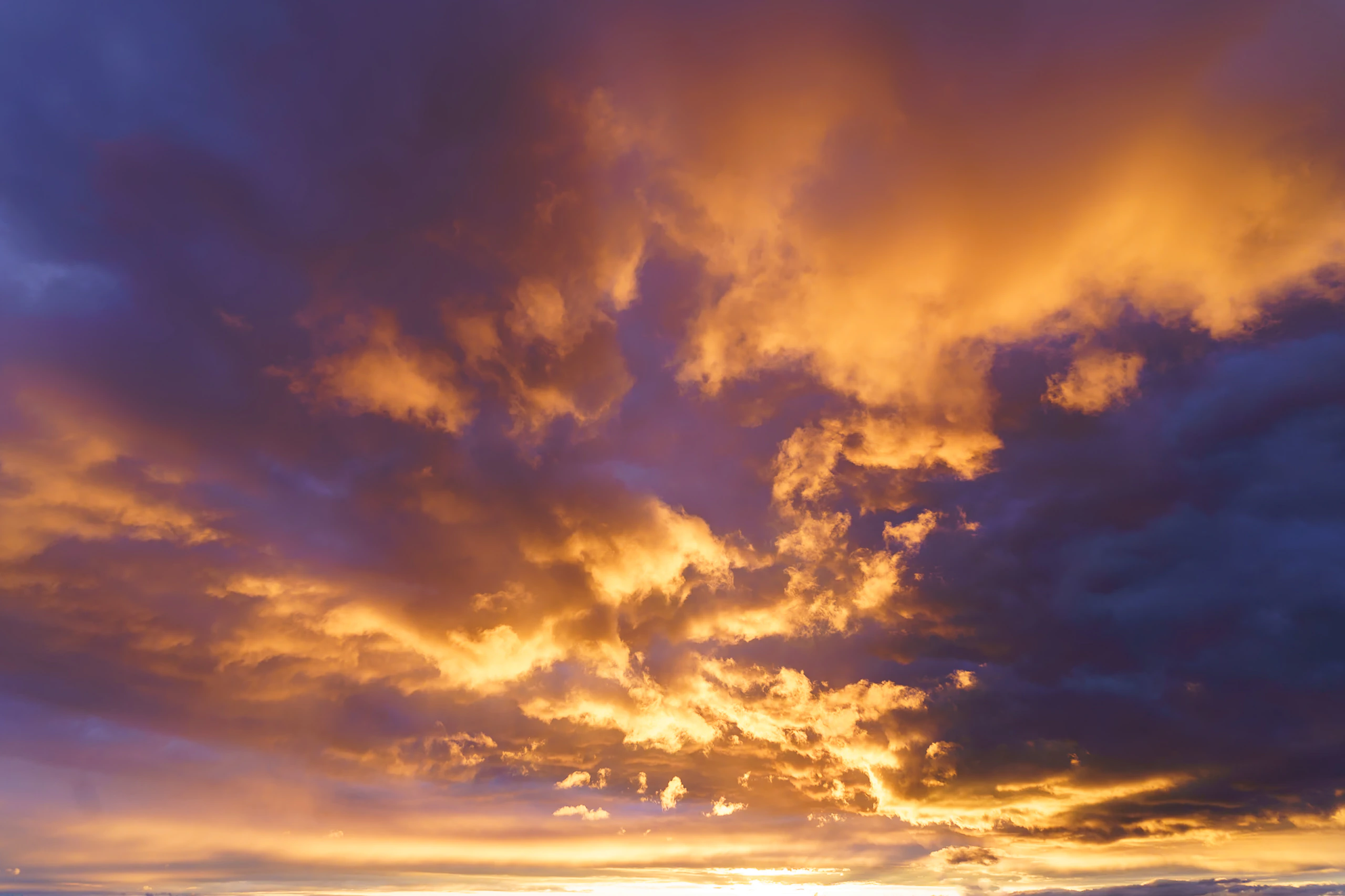 Clouds illuminated in intense orange and violet light