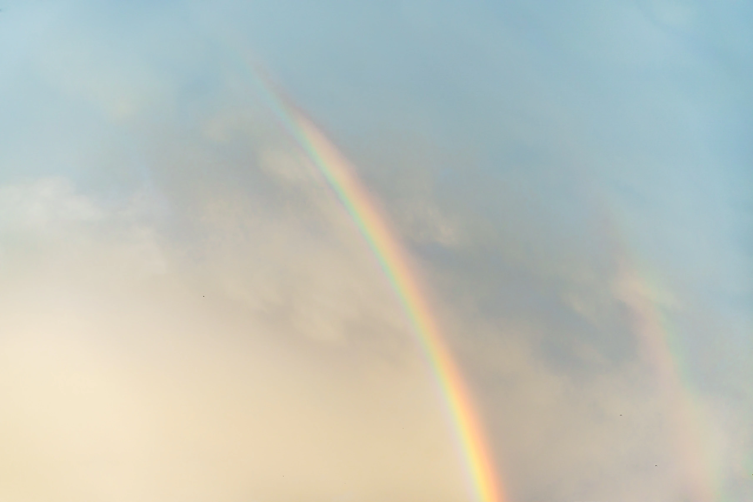 A double rainbow fading into warm light