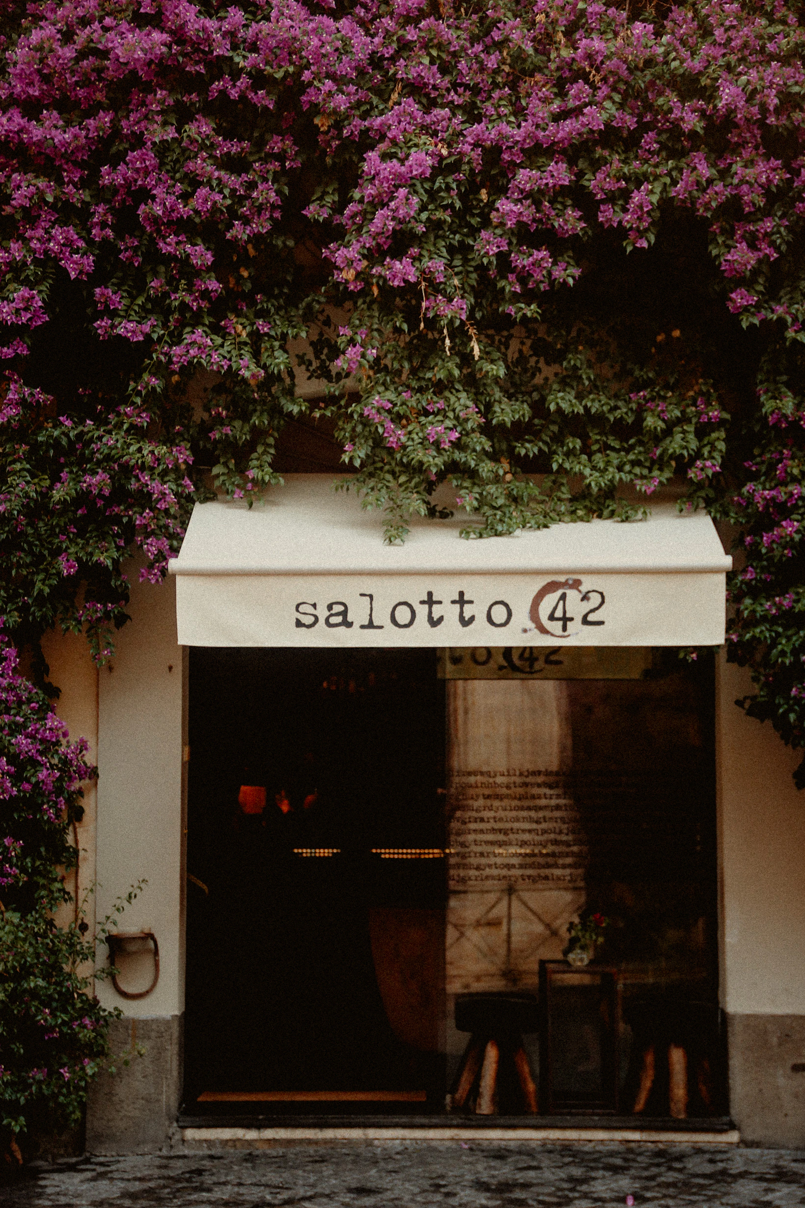 A doorway framed by vivid bougainvillea in Rome