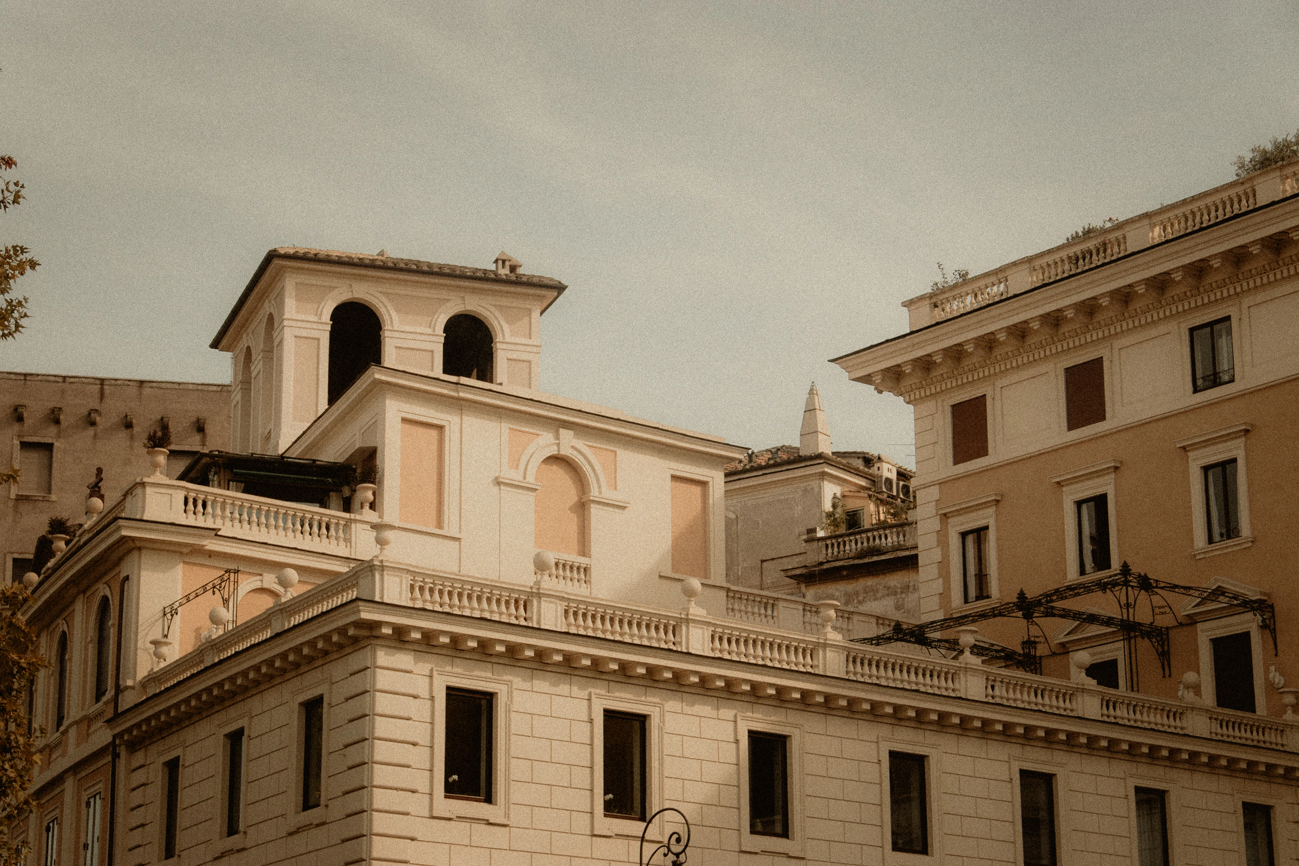 Layered pale and ochre Roman architecture beneath a muted sky