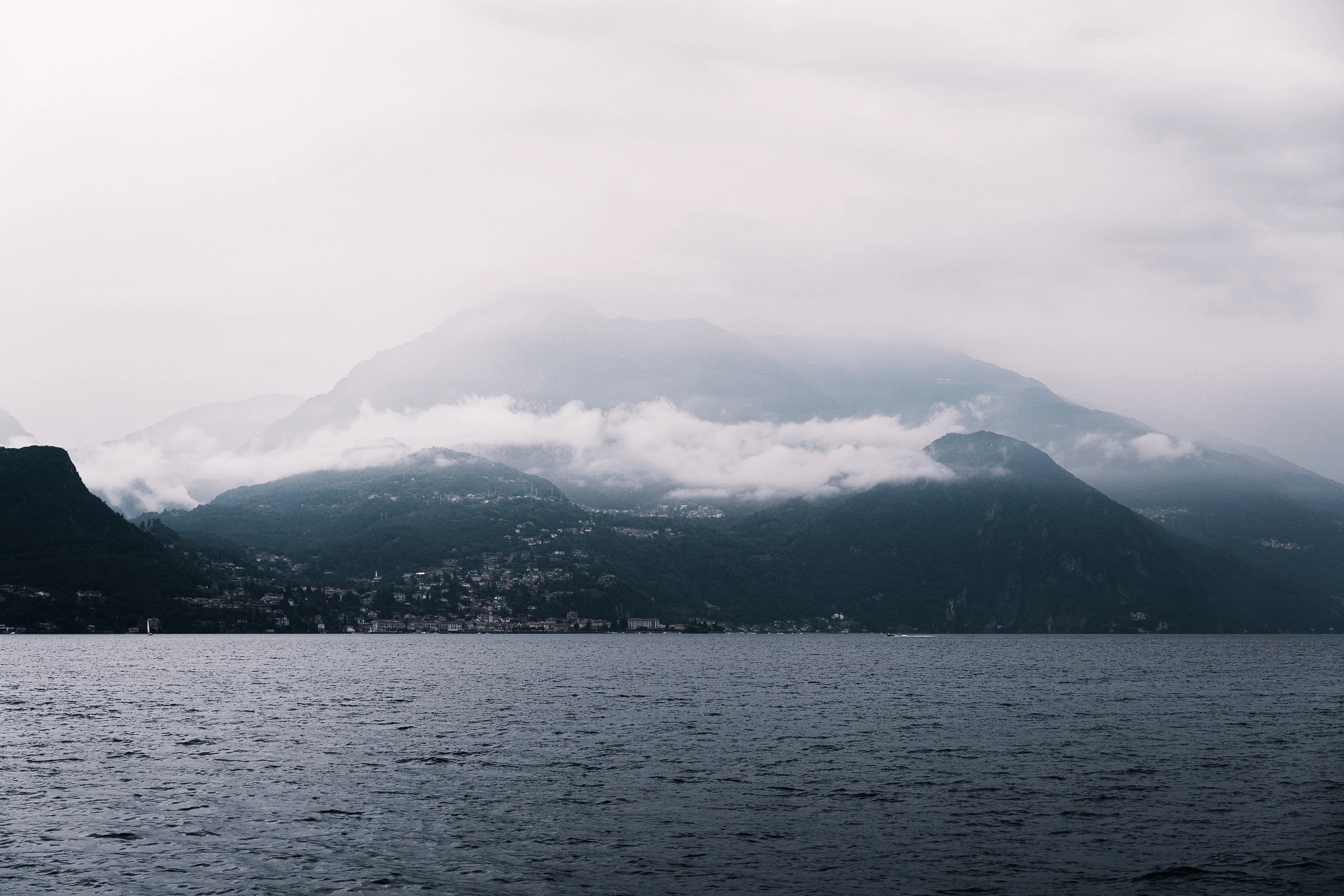 A mountain settlement almost erased by a low horizontal blanket of cloud