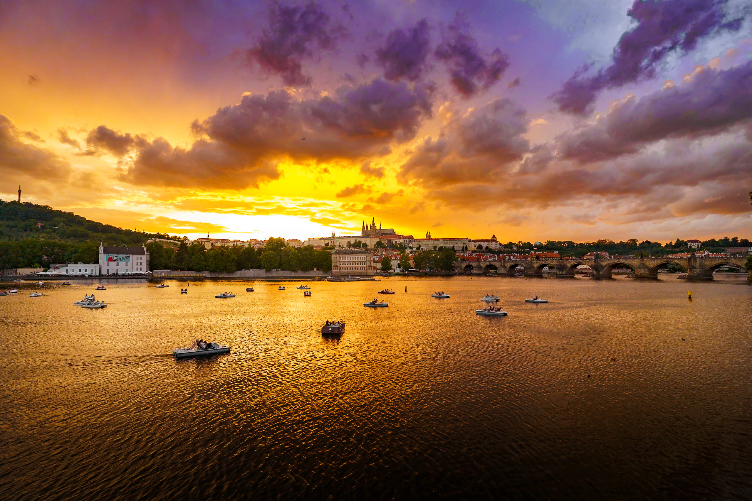 Prague and Charles Bridge beneath a dramatic golden sunset