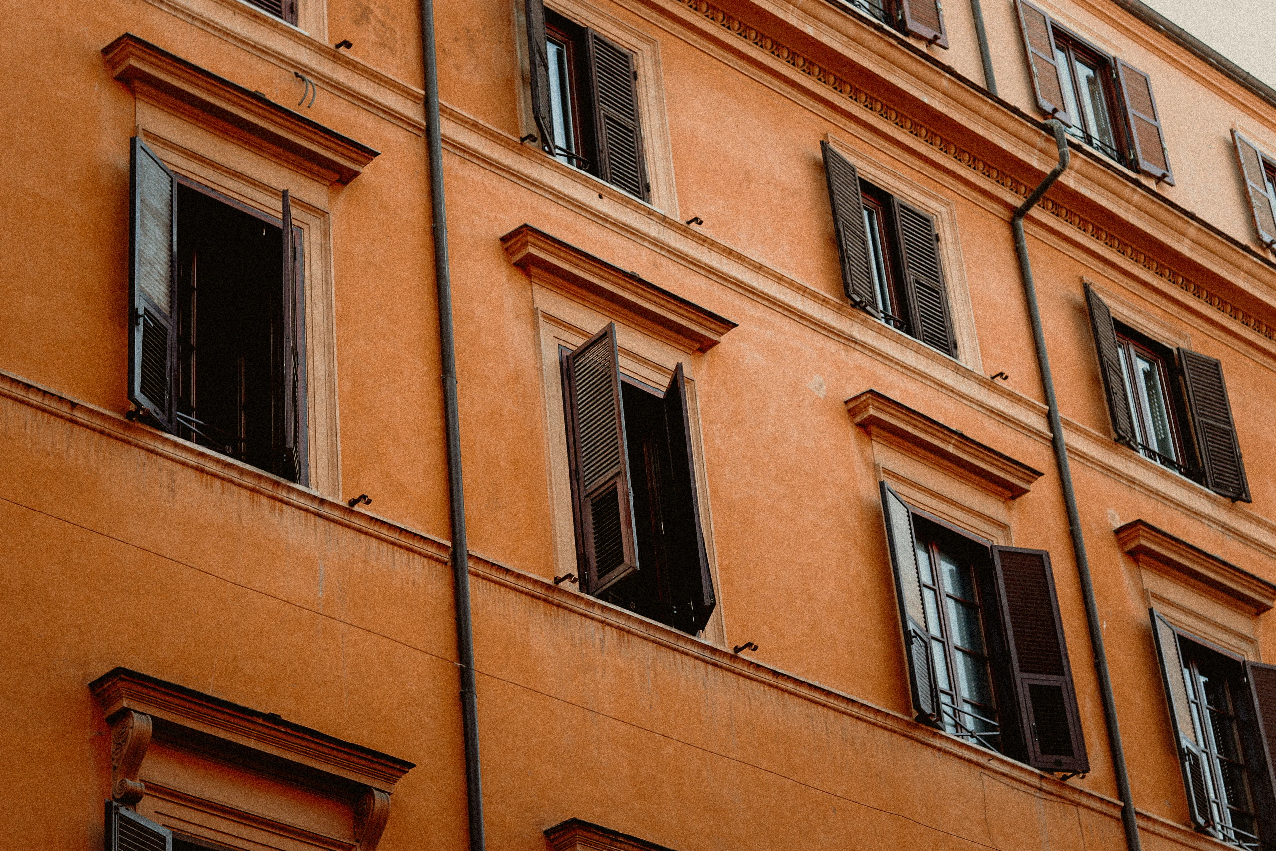 Open dark shutters across a warm orange facade