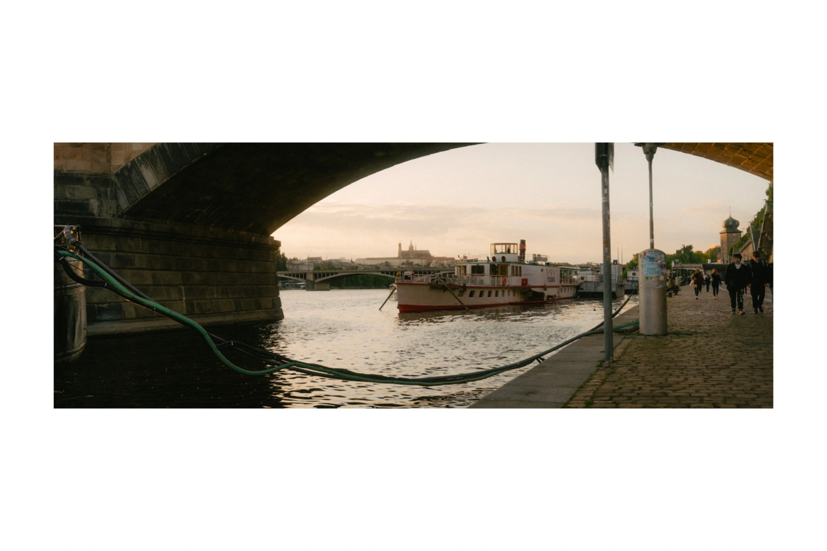 A boat moored beneath a bridge at dusk