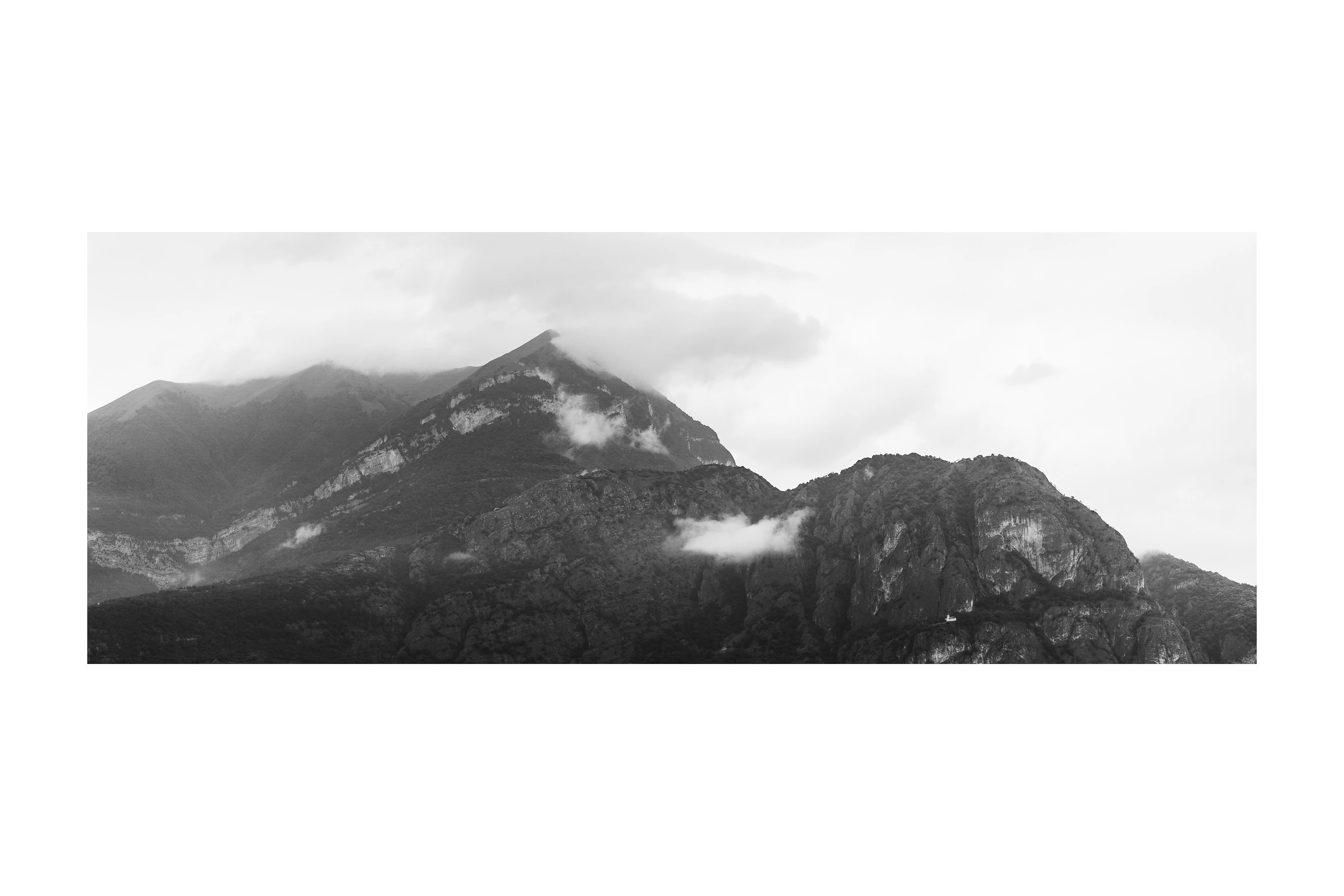 Black-and-white mountain ridges emerging from low cloud